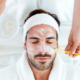 A relaxed man receiving a detox facial treatment at a med spa.